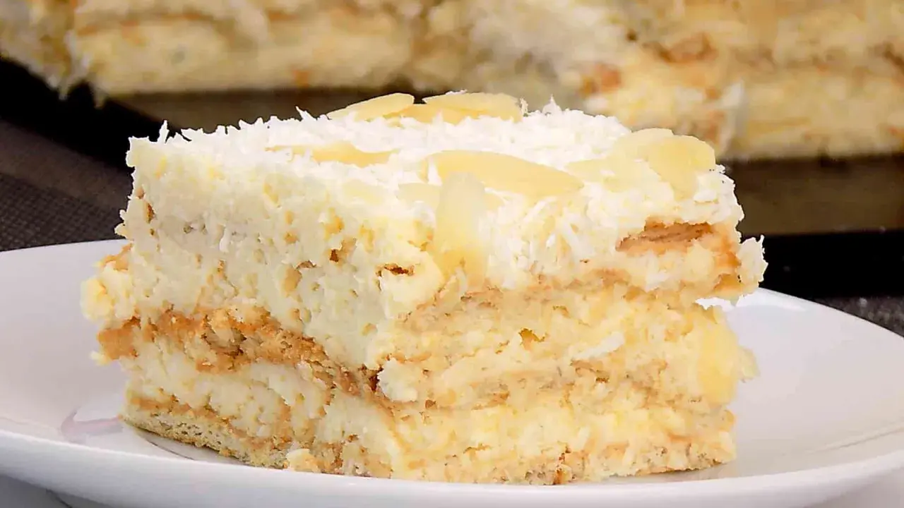 Kawałek puszystego ciasta Rafaello z kremem kokosowym i migdałami. Idealny prosty przepis na domowe ciasto.