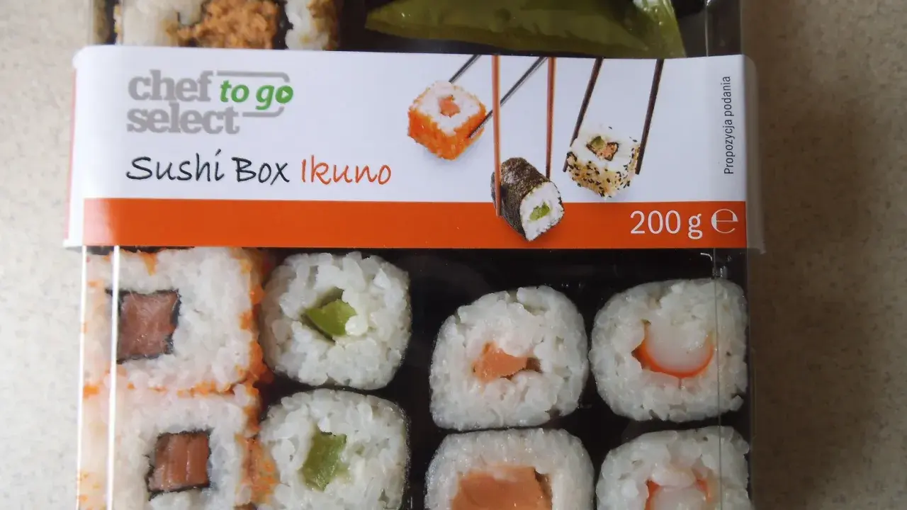 Pudełko z **lidl sushi** Chef to Go Select Ikuno, zawiera różne rodzaje rolek z łososiem, awokado i krewetkami.