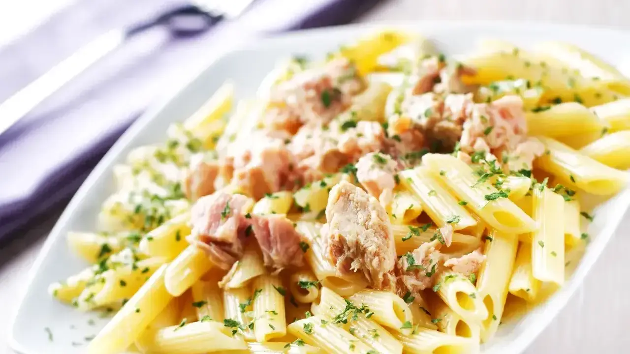 Penne z tuńczykiem w sosie własnym, posypane natką pietruszki. Proste i pyszne danie.