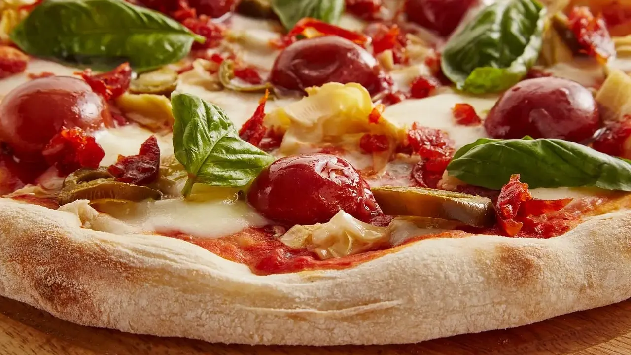 Pyszna pizza włoska z pomidorkami, mozzarellą i bazylią. Idealny przepis na domową ucztę.