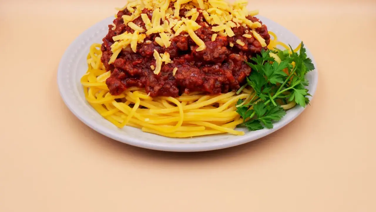 Spaghetti bolognese z tartym serem i natką pietruszki. Prosty przepis na pyszny obiad.