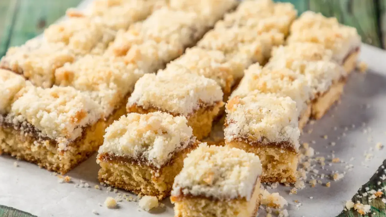 Szybkie ciasto na niedzielę do kawy, pokrojone w kostkę, z warstwą dżemu i kruszonką. Idealne na leniwe popołudnie.