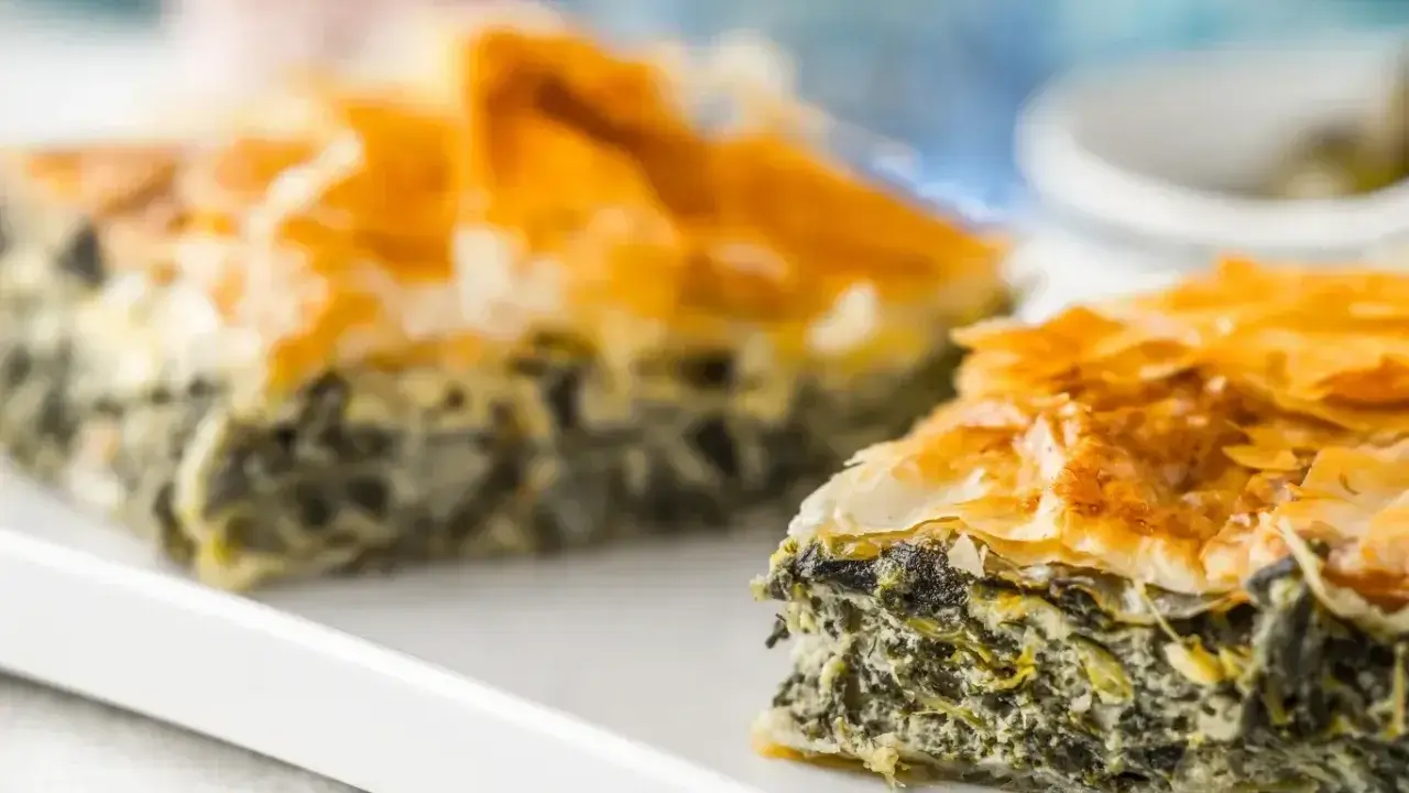 Chrupiąca, złocista spanakopita z warstw ciasta filo i aromatycznym nadzieniem ze szpinaku i sera feta.