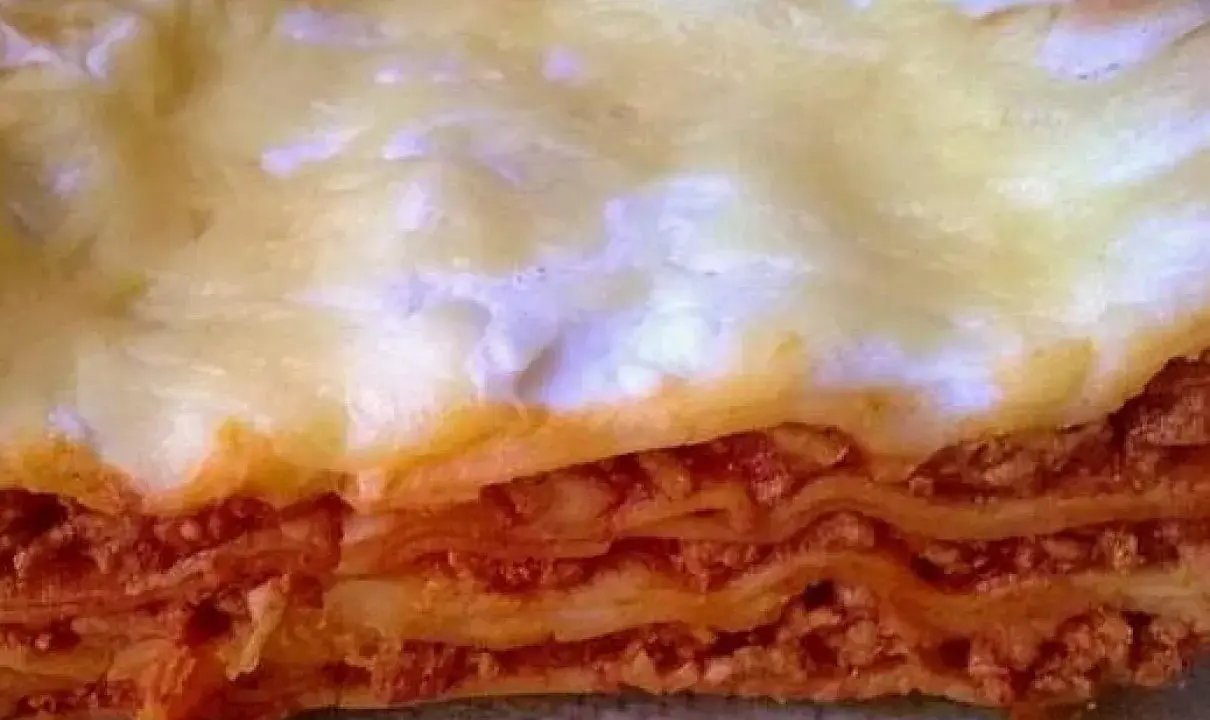 Warstwy makaronu, sosu mięsnego i sera tworzą apetyczny przekrój lasagne. Idealny prosty przepis na lasagne z mięsem mielonym.