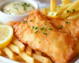 Chrupiąca ryba w cieście, podana z frytkami, cytryną i sosem tatarskim. Idealny posiłek na szybki lunch.