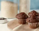 Wilgotne i puszyste muffinki czekoladowe, idealne na każdy dzień. Składniki do ich przygotowania w tle.