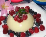 Panna cotta z malinami i borówkami, posypana cukrem pudrem. Idealny deser, który można zrobić według prostego legumina przepisu.