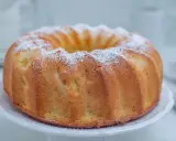 Szybka babka wilgotna, oprószona cukrem pudrem, prezentuje się apetycznie na białej paterze. Idealna na szybką przekąskę.