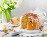 Pyszna babka włoska z lukrem i czekoladową posypką, udekorowana na Wielkanoc z tulipanami i kolorowymi jajeczkami.