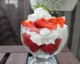 Pyszne, świeże truskawki ze śmietaną w pucharku, gotowe do schrupania.