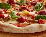 Pyszna pizza włoska z pomidorkami, mozzarellą i bazylią. Idealny przepis na domową ucztę.