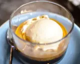 Pyszne affogato: gałka lodów waniliowych w gorącym espresso, podana w szklance na niebieskim talerzyku.