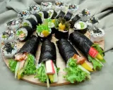 Talerz pełen pyszności: sushi z łososiem, awokado, krabem i warzywami. Idealne na co do sushi.