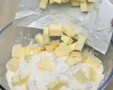 Kawałki zimnego masła dodawane do mąki w misce, kluczowy krok w sprawdzonym przepisie na kruche ciasto.