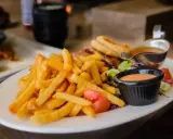 Porcja frytek z sosem i sałatką. Zastanawiasz się, ile kalorii ma porcja frytek?