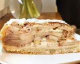 Pyszny kawałek szarlotki z warstwami jabłek i kremu, posypany cukrem pudrem. Idealna na deser, aż chce się ją piec!