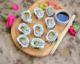 California sushi z łososiem i awokado, posypane czarnym sezamem, podane z sosem sojowym i wasabi.