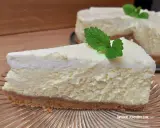 Pyszny sernik ze śmietaną kremówką, udekorowany listkiem mięty, na kruchym spodzie.