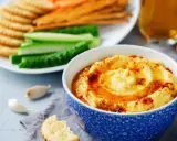 Pyszny, kremowy hummus, idealny jako sos do frytek, podany z chrupiącymi krakersami i świeżymi warzywami.