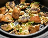 Pyszne pieczarki z airfryer, przyprawione i posypane natką pietruszki, gotowe do podania.