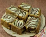 Puszyste ciasto zebra przepis. Pokrojone kawałki ciasta z charakterystycznym wzorem zebry ułożone na drewnianej desce.