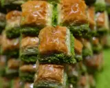 Słodka, złocista baklava, co to za przysmak! Warstwy ciasta filo, orzechów i syropu, posypane zielonymi pistacjami.