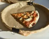Kawałek pizzy z pieczarkami na papierowym talerzu. Zastanawiasz się, ile kalorii ma średnia pizza?
