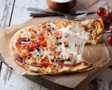 Ciągnący się ser z pizzy 32 cm z pomidorkami i cebulą. Zastanawiasz się, ile kcal ma pizza 32 cm?
