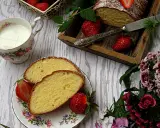 Pyszne ciasto z żółtek, udekorowane cukrem pudrem i truskawkami, podane z mlekiem.