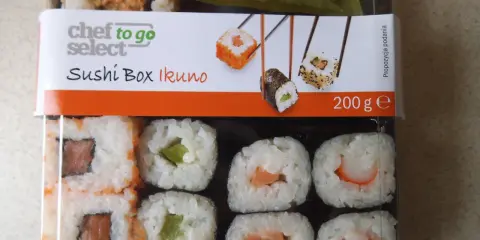 Pudełko z **lidl sushi** Chef to Go Select Ikuno, zawiera różne rodzaje rolek z łososiem, awokado i krewetkami.