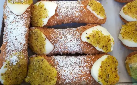 Pyszne, chrupiące rurki z kremem i pistacjami. Idealny dobry przepis na ciasto na rurki, posypane cukrem pudrem.