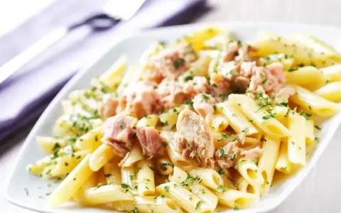 Penne z tuńczykiem w sosie własnym, posypane natką pietruszki. Proste i pyszne danie.