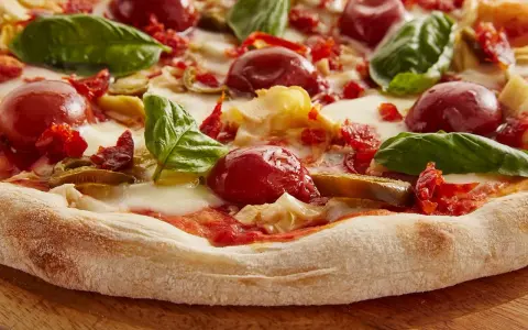 Pyszna pizza włoska z pomidorkami, mozzarellą i bazylią. Idealny przepis na domową ucztę.