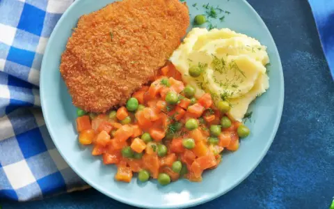 Idealne danie co na sobotni obiad: panierowany kotlet, puree ziemniaczane z koperkiem i warzywa w sosie.
