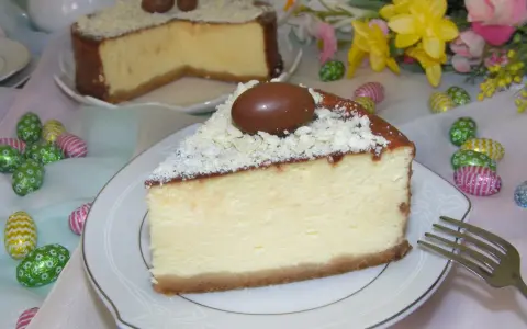 Wspaniały sernik z mascarpone, udekorowany czekoladowymi jajeczkami i wiórkami białej czekolady, idealny na Wielkanoc.