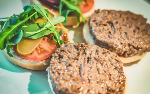 Gotowe hamburgery z Biedronki: jak przyrządzić pyszne burgery z rukolą, pomidorem i ogórkiem.