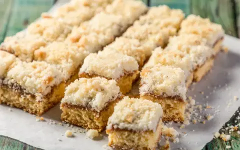 Szybkie ciasto na niedzielę do kawy, pokrojone w kostkę, z warstwą dżemu i kruszonką. Idealne na leniwe popołudnie.