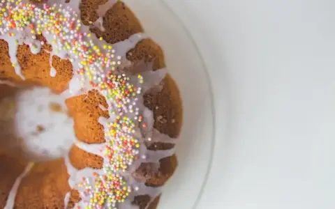 Babka z kolorową posypką i lukrem pomarańczowym, gotowa na święta.