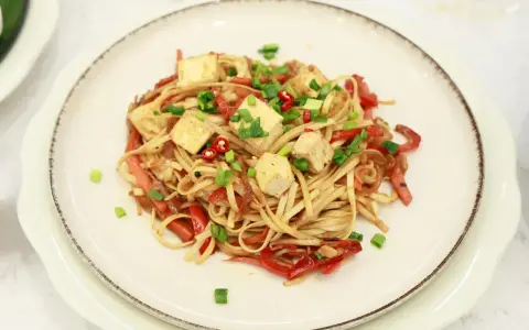 Pyszny makaron z tofu, papryką i szczypiorkiem, posypany chili. Idealne danie dla wegan.