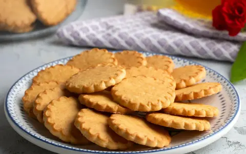 Stos pysznych, szybkich kruchych ciasteczek na talerzu z niebieskim wzorem. Idealne na popołudniową herbatkę.
