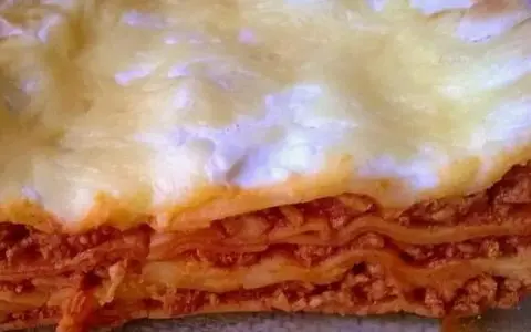 Warstwy makaronu, sosu mięsnego i sera tworzą apetyczny przekrój lasagne. Idealny prosty przepis na lasagne z mięsem mielonym.