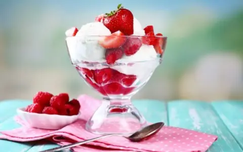 Pyszne lody nuii z malinami i truskawkami w pucharku.