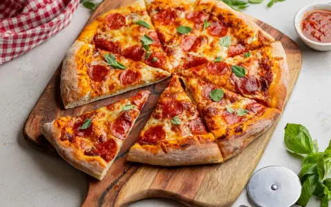 Pyszna pizza pepperoni z ciągnącym się serem i świeżą bazylią, gotowa do podania.