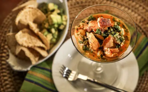 Pyszne ceviche z łososiem w kieliszku, obok miseczka z awokado i chipsami. Idealne na letni obiad.