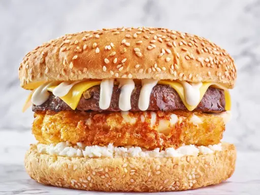 Apetyczny burger drwala przepis: soczysta wołowina, chrupiące panierowane ziemniaki, ser i biały sos na sezamowej bułce.