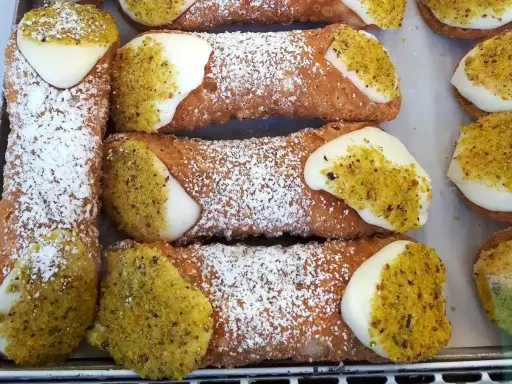 Pyszne, chrupiące rurki z kremem i pistacjami. Idealny dobry przepis na ciasto na rurki, posypane cukrem pudrem.