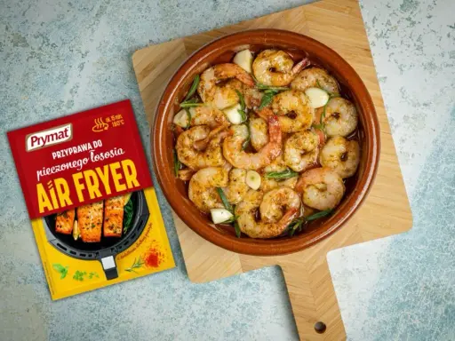 Aromatyczne krewetki z airfryer, gotowe w kilkanaście minut. Obok opakowanie przyprawy Prymat do pieczonego łososia.