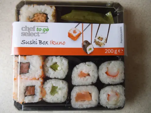 Pudełko z **lidl sushi** Chef to Go Select Ikuno, zawiera różne rodzaje rolek z łososiem, awokado i krewetkami.