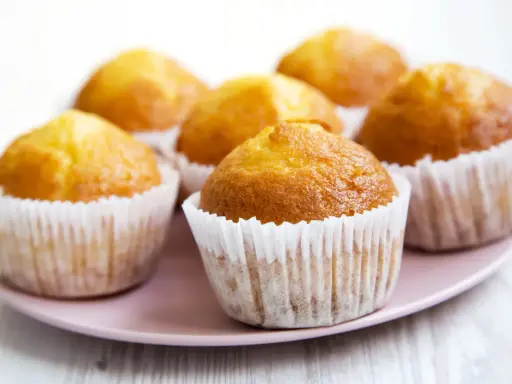 Puszyste muffinki na talerzyku, idealne do kawy. Ten przepis na wilgotne i puszyste muffinki sprawi, że będą smakować wybornie.