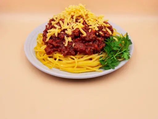 Spaghetti bolognese z tartym serem i natką pietruszki. Prosty przepis na pyszny obiad.